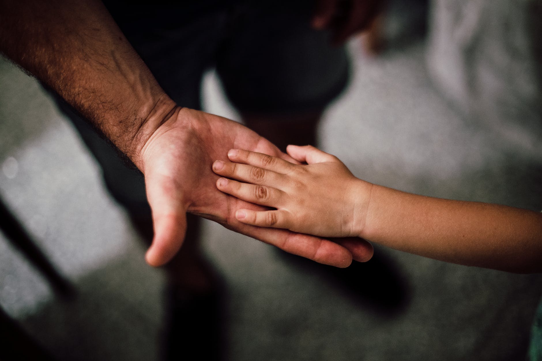 selective focus photography of child s hand on person s palm
